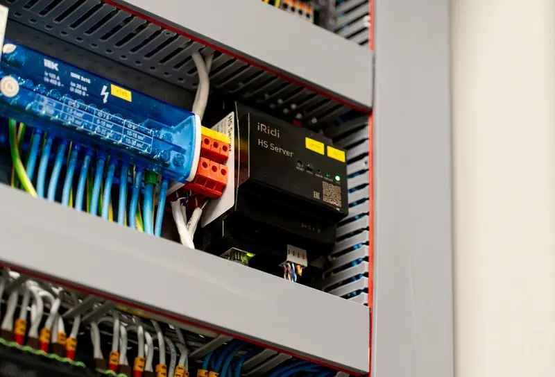 Open control cabinet with a PLC rack, I/O modules and wiring