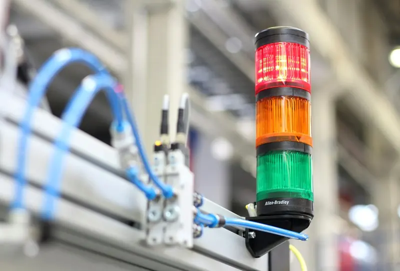 Sensor cables and an industrial signal tower on a machine frame